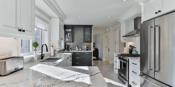 High End Kitchen Renovation with quartzite countertops, sub zero, white and black cabinets.