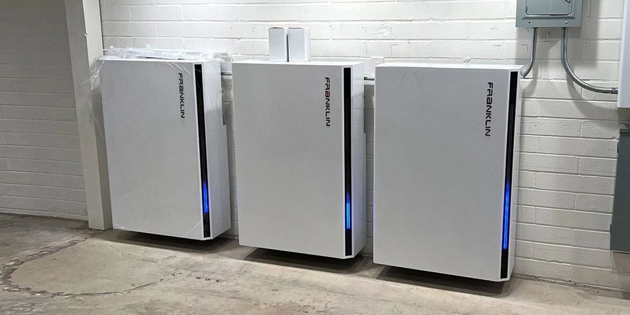 Three white Franklin battery storage units mounted on a basement wall.