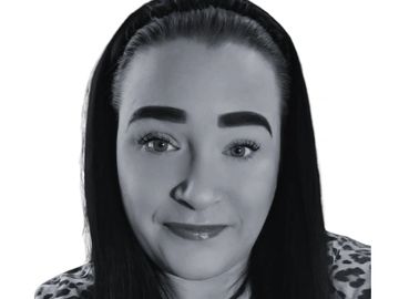 Black and white portrait of a woman with a headband and patterned top.