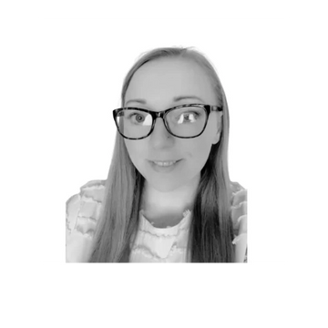 Black and white portrait of a smiling woman with glasses and long hair.