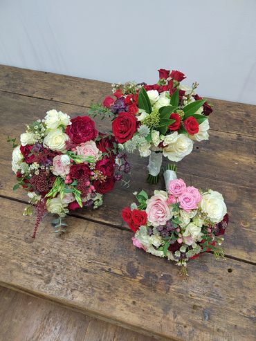 red, white and pink bridal bouquet and two bridesmaids bouquets