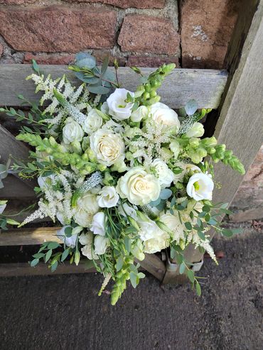 Hand tied bridal bouquet all in white, including roses, astilbe, Veronica, Lizzie and snapdragon.