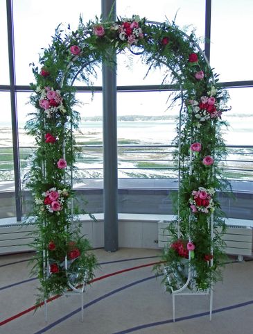 Wedding arch with pink and white floral bouquets