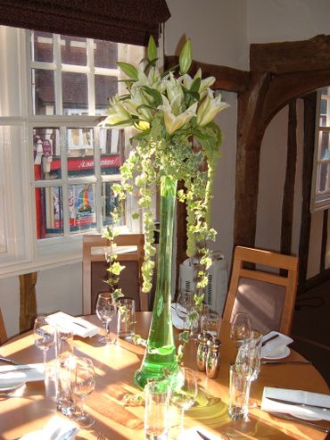 White lily and green Ivey, tall glass vase arrangement by Arabella's flowers
