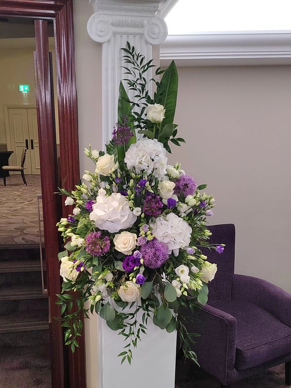 Wedding pedestal arrangement at the Grand Hotel on Jersey made up of white Hydrangea and roses.