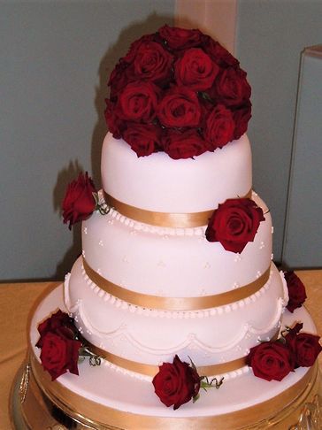 wedding cake with fresh red rose arrangements