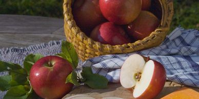 Apples in a basket and a cut apple on a cutting board