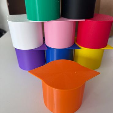 Colorful stacked cylindrical containers with flat lids.