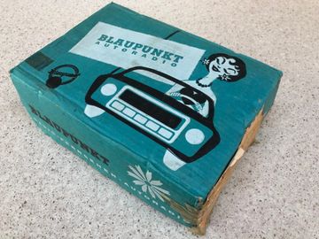 Vintage Blaupunkt Autoradio box with retro car and woman illustration.