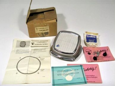 Vintage car headlight assembly with original packaging and instructions.
