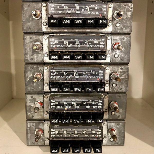 Stack of vintage Blaupunkt car radios with AM, SW, and FM buttons.