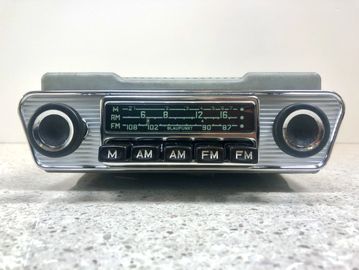 Vintage car radio with AM and FM buttons and tuning knobs.