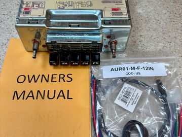 Vintage car radio with owner's manual and wiring harness kit.
