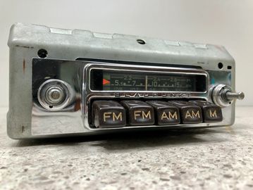 Vintage car radio with FM and AM buttons and tuning dial.