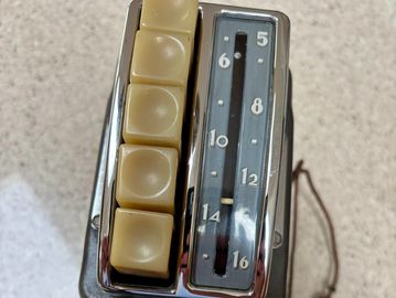 Vintage mechanical counter with four cream-colored buttons and a numbered display.