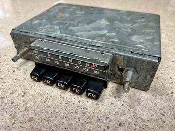 Vintage car radio with AM/FM buttons and tuning dial.