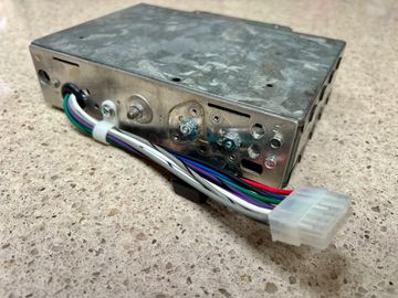 Metal electronic component with a multi-colored wire harness and connector.