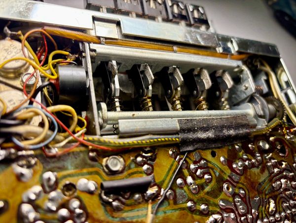 Close-up of an electronic circuit board with mechanical components and wires.