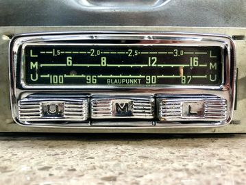 Close-up of a vintage Blaupunkt car radio with tuning scale and buttons.