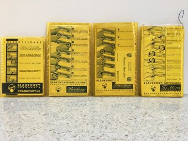 Old Blaupunkt car radio manuals with yellow covers displayed side by side.
