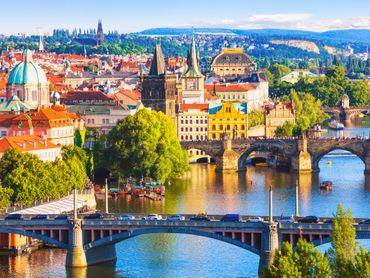 Scenic view of Prague with historic bridges and colorful buildings along the river.
