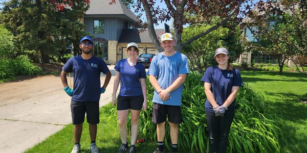 Earth Angel Gardening team of 4 people standing in front of a yard.