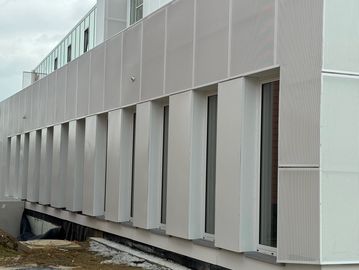 Façade moderne avec de grandes fenêtres verticales.