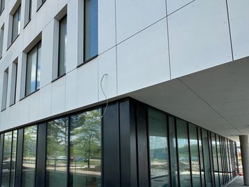 Façade moderne avec grandes fenêtres et panneaux blancs.