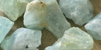 Several aquamarine stones on a flat surface.