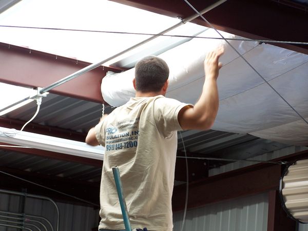 Man installing insulation in ceiling