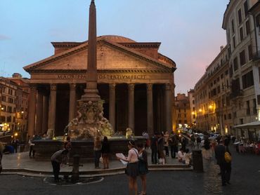 Evening scene at the Pantheon with people and fountain in Rome.