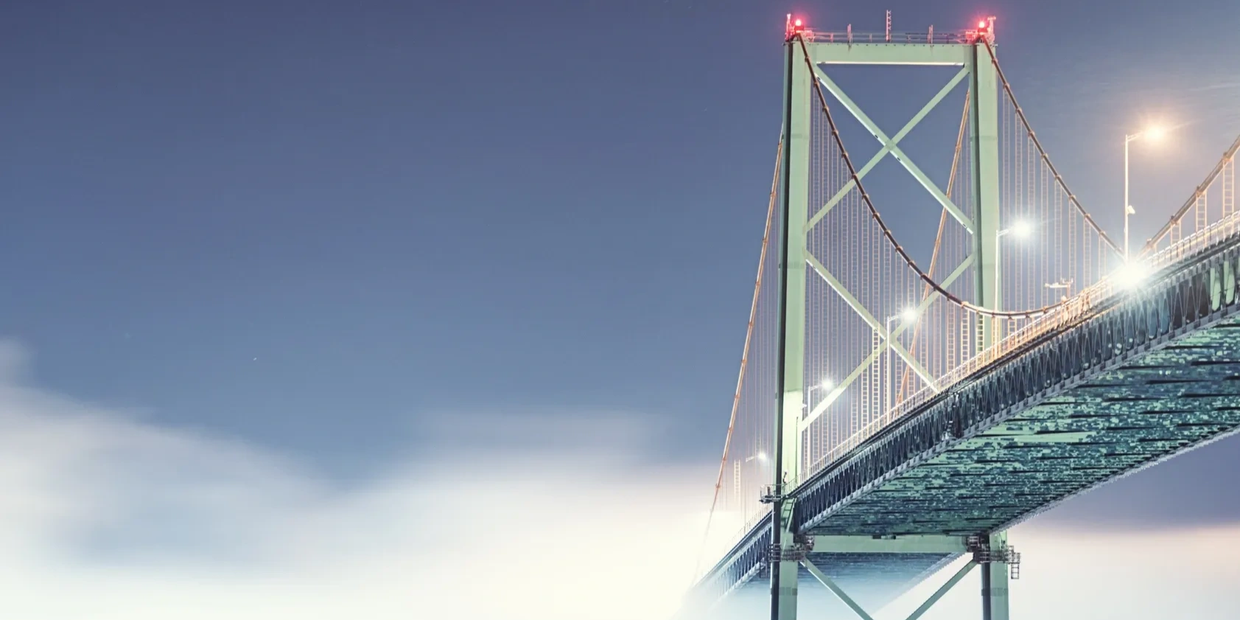 A bridge lit up at night under a clear sky.