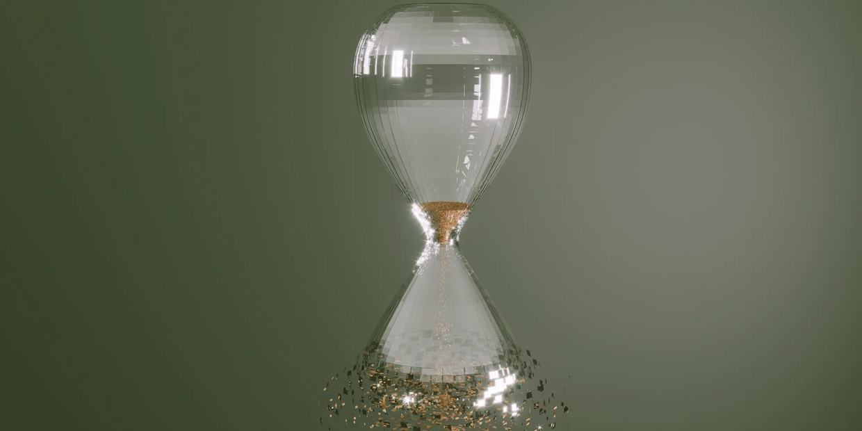 A transparent hourglass with golden particles.