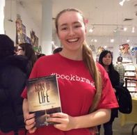 An excited fan at the Books of Wonder mega signing purchases Signs of Life, good teen fiction to read!
