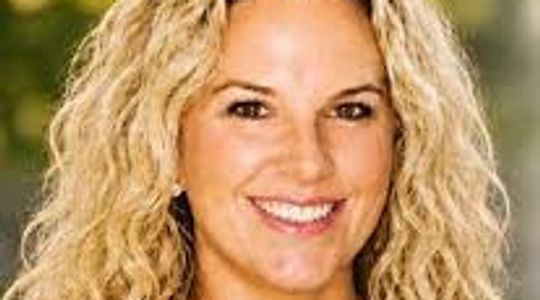 Smiling woman with curly blonde hair.