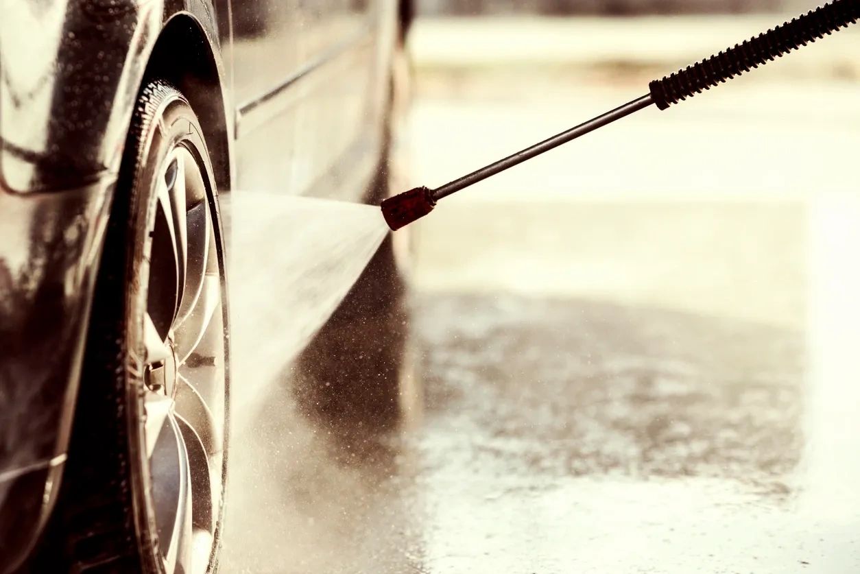 Pressure washing a car wheel.