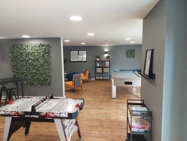 An open lounge area with hockey table and pool table