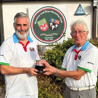 Two men holding a trophy at Windsor and Eton Bowling Club.