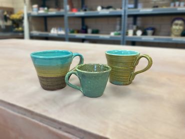 three green mugs of varying sizes