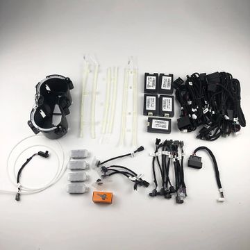 Various electronic components and wiring harnesses laid out on a white surface.