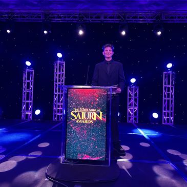 Person standing at a podium for the Saturn Awards.