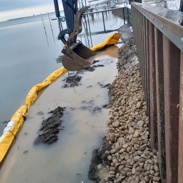 Heavy machinery pushing rocks to the seawall