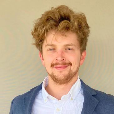 Young man with curly hair in a blazer.