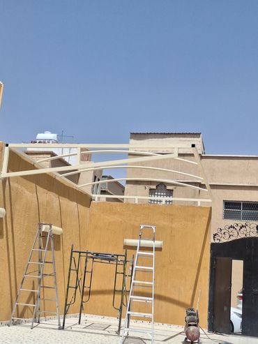 Construction ladders and scaffolding against beige walls.