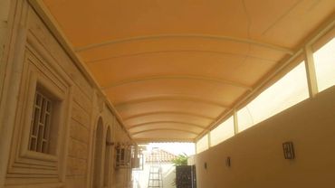 Covered patio with a yellow roof and beige walls.