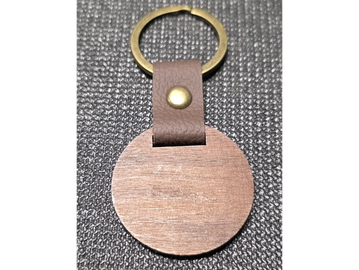Close-up of a keychain with a brass ring and leather strap.