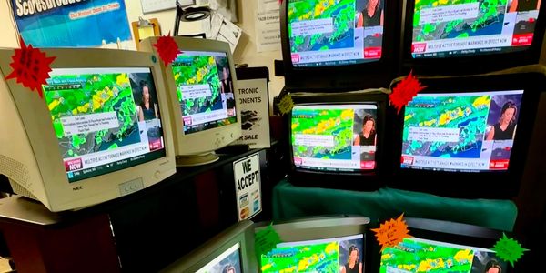 Multiple televisions displaying a weather forecast.