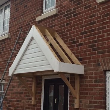 A side view of the construction of a canopy that is added to the front of a new build property.