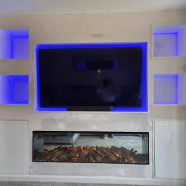 A custom media wall that incorporate LED lighting within the shelving area. To display a tv and firec