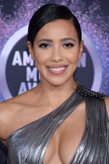 Woman with shiny silver dress smiling at the camera.